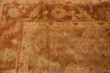 Lustrous gold-cast pile and rust floral border on a hand-knotted Oushak rug corner.