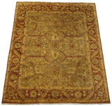 Angled view of the gold wash Indian Oushak carpet showing its lustrous pile and large-scale arabesque design.