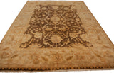 Perspective view of a lustrous Indian Oushak carpet with a floral brown and gold design.