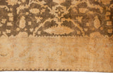 Golden brown palmette border and floral field on a lustrous Indian Oushak design carpet.