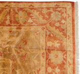 Vintage Indian Oushak rug with rust and golden olive vine border, plush pile, and cream fringe.