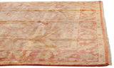 Corner of Indian Oushak carpet showing polished gold and copper hues, serrated leaf border.