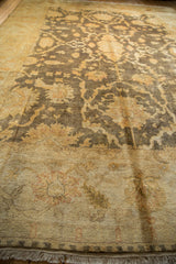 Ivory fringe, light end border, and dark field with gold floral Oushak design.