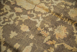 Lustrous pile with charcoal, dusty gold, and bronze floral vinery of the Oushak rug.