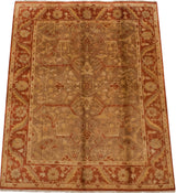 Angled view of a hand-knotted Indian Oushak carpet with a floral design in gold and rust.