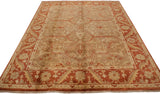 Low angle view highlighting the lustrous gold-green pile and rust floral border of an Oushak carpet.