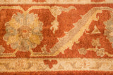 Meandering palmette border detail in rust, gold, and dusty green on a plush hand-knotted pile.