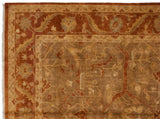 Corner of an Indian Oushak rug showing the rust palmette border and intact side cord selvage.