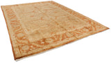 Angled view of the entire gold Oushak carpet with a rust floral and palmette border.
