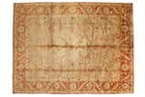 A gold wash Oushak design rug with an allover floral field and a wide, rust-colored palmette border.