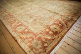 Polished sheen across the gold and terra cotta floral design of an Indian Oushak carpet.