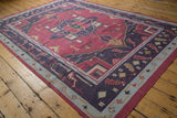 A vintage Indian Dhurrie rug viewed from a high angle, showing its geometric medallion and border design.