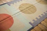 Orange circle, pale blue stripe, and charcoal stepped geometric edge of a contemporary kilim.