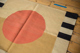 Hand woven Kilim texture displaying a vivid rust red circle and charcoal striped edge.