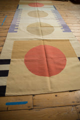 Hand woven contemporary Kilim runner: madder root rust red circle, beige field, charcoal stripes.