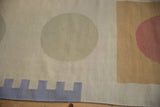 Abstract madder root red, dark saffron, and mauve motifs on an ivory flatweave Kilim.