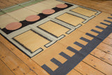 Contemporary kilim rug detail: sand geometric squares, black track trails, pale silver, navy patterns.