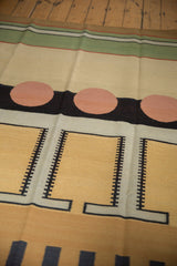 Abstract hand woven kilim rug with pale cinnabar circles and black ladder patterns.