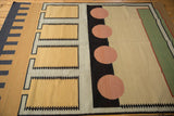 Vintage kilim rug detail: pale cinnabar red circle, black track trails.