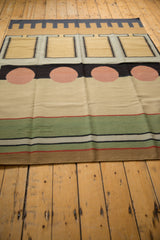Contemporary hand woven Kilim rug edge shows pale green, red, black, and ivory stripes.
