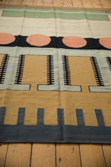 Contemporary Kilim rug detail with pale cinnabar circles, charcoal, and bronze geometric track patterns.