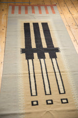 Contemporary kilim runner's abstract geometric charcoal blocks, light beige, and stepped silver pattern.
