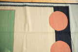 Abstract contemporary Kilim rug with sand, charcoal, emerald green, and red circles.