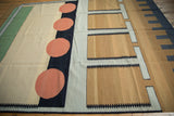 Playful geometric patterns on hand woven kilim, featuring coral circles and gold blocks.