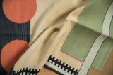Textural detail of a contemporary kilim with cinnabar red circles and black geometric patterns.