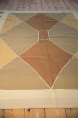 Hand-woven contemporary kilim rug with beige border and geometric diamond pattern.