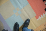 Abstract geometric contemporary Kilim runner with pinwheel coloration in sand, blue, and coral.