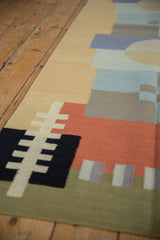 Contemporary Kilim rug displaying black, sand, and madder red geometric blocks and side edge.