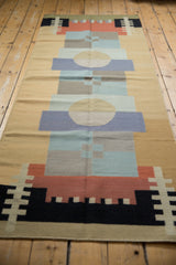 Abstract geometric pattern featuring black, red, and sand blocks on a kilim runner.