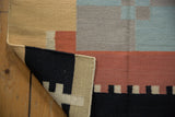 Close-up of the hand woven Contemporary Kilim rug corner, showing intact sand-colored side cord selvage.