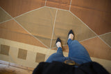 Modern geometric Argyle diamond pattern on a Kilim carpet in copper and sand tones.