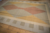 Angled view of a contemporary Kilim rug's argyle diamond pattern in warm copper and gold tones.