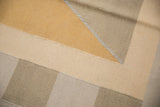 Argyle-inspired geometric pattern of the kilim rug with beige, gold, and ivory shades.