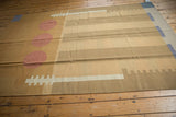Contemporary Kilim rug displaying abstract rectangular pillars and pale cochineal red circles.