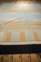 Abstract columns of circles and reciprocating motifs in beige, gold, mint, and black on a vintage Kilim rug.