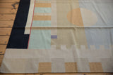 Contemporary kilim with abstract blocks, black border, beige, pale mint green, and gold.