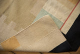 Folded contemporary Kilim carpet revealing hand woven edge, with beige, black, red, and gold.