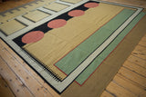 Corner of contemporary Kilim rug with black dashes, madder root red, and ivory abstract shapes.