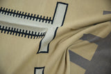 Folded detail of hand woven contemporary Kilim carpet, showcasing ivory, black, sand, and charcoal geometric motifs.