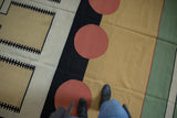 Abstract geometric design of a hand woven kilim with madder root red circles and black stripes.