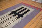 Abstract geometric Kilim rug runner with purple, black, and ivory staggered patterns.