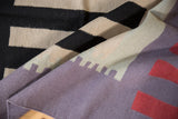 Contemporary Kilim rug showcasing abstract charcoal, ivory, dusty blue, and red geometric patterns.