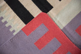 Hand woven geometric detail of the Contemporary Kilim in red, purple, beige, and black.