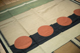 Abstract geometric contemporary Kilim with pale brick red circles and interlocked black patterns.