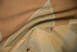 Draped detail of hand-woven Kilim texture with pale copper, sand, and beige diamond pattern.