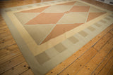 Modern Kilim rug's geometric diamond motif in alternating pale copper and beige tones.